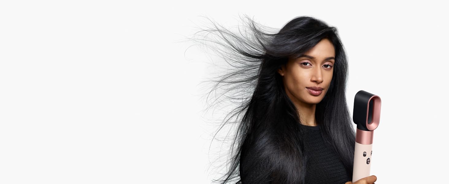 Model uses the Dyson Airwrap i.d.with the fast dryer attachment to style her hair.