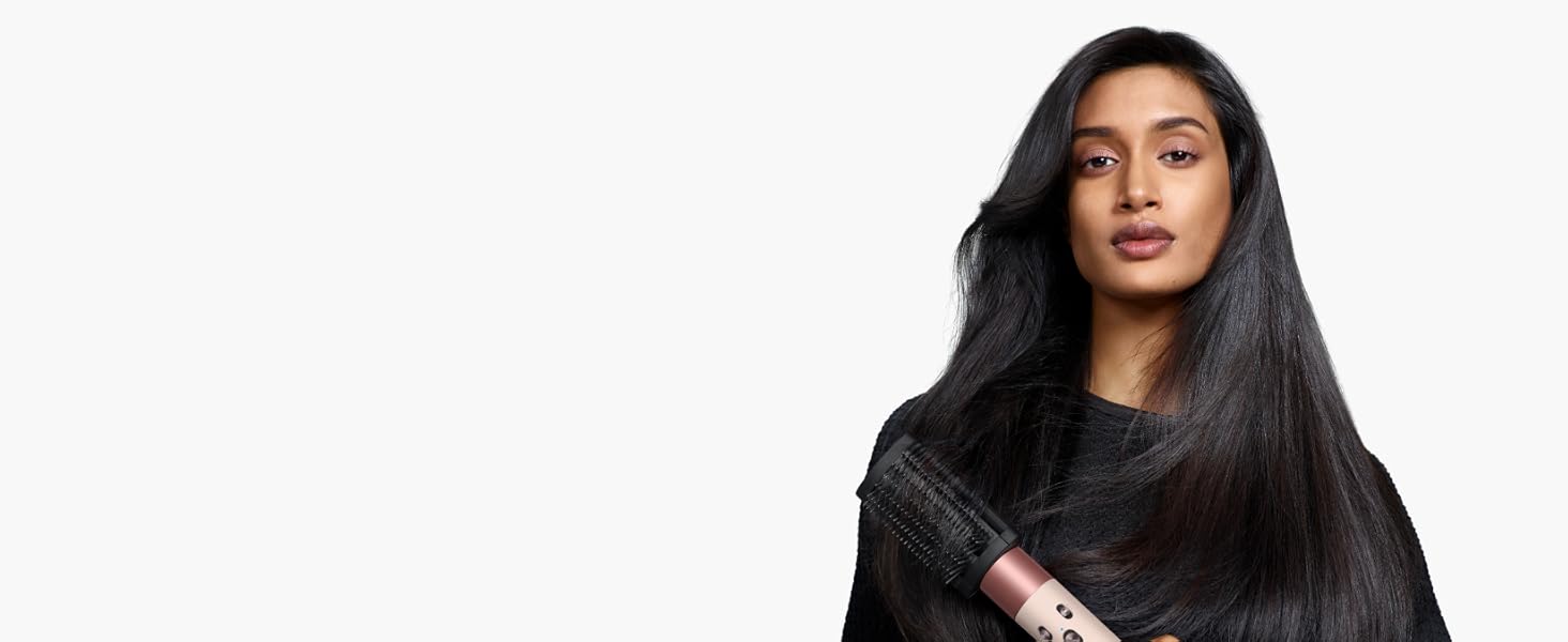 model uses the Dyson Airwrap i.d. with the smoothing brush attachment to style her hair.