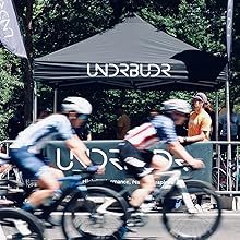 Cyclists riding past chamois cream tent