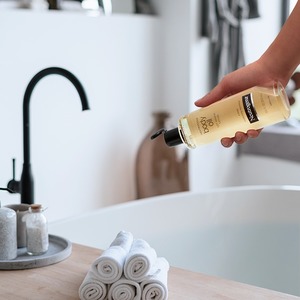 Neutrogena Moisturizing Sesame Body Oil for dry skin being poured into bath tub