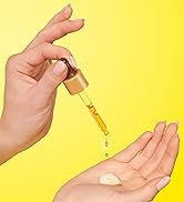 Woman using a serum dropper tp dispense product