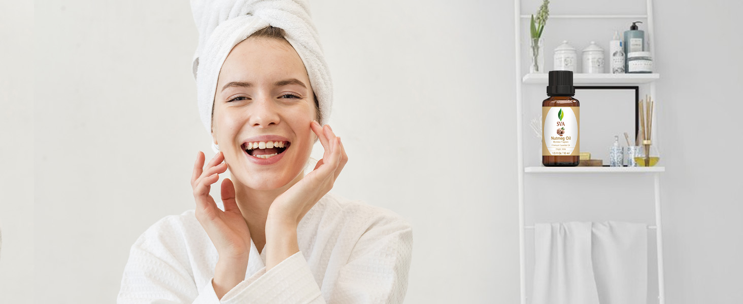 A lady applying nutmeg essential oil on her face from the amber glass bottle for skincare