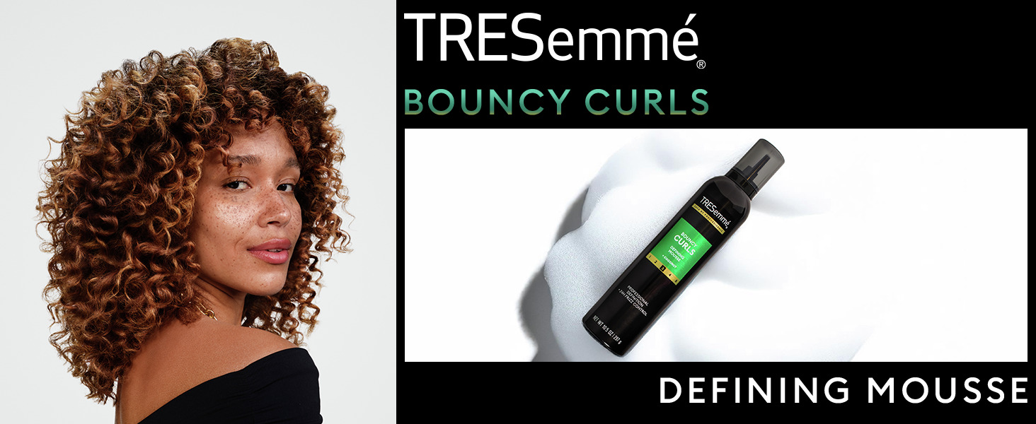 Woman with bouncy curls next to TRESemmé mousse bottle on a clean background.