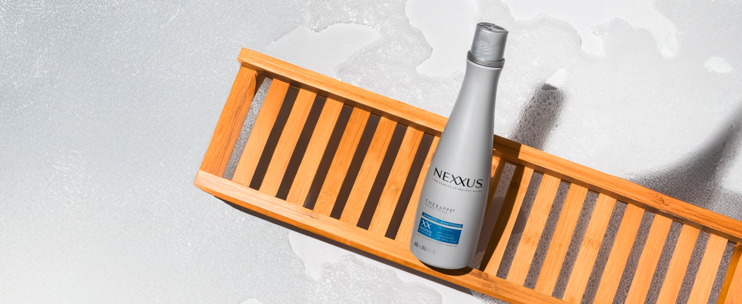 Nexxus Therappe Ultimate Moisture shampoo bottle on top a wooden furniture.