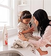 Bottle of Jergens Original Scent Lotion on counter next to a child with her mother.