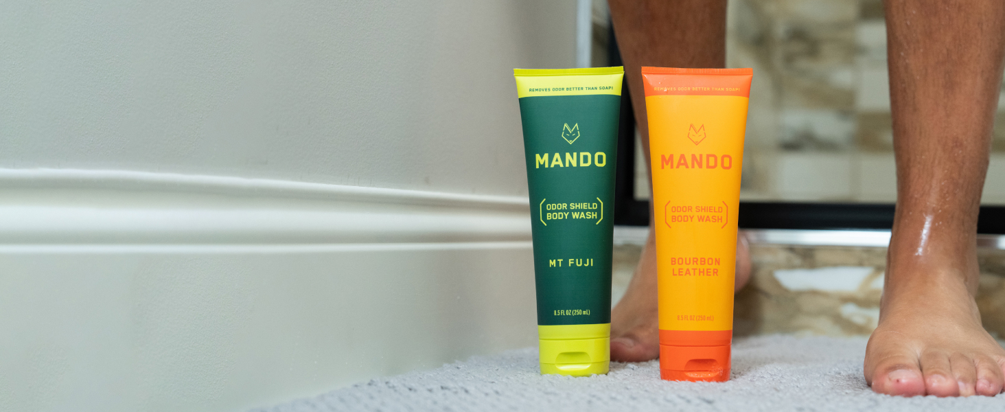 person stepping out of shower with two scents of body wash nest to their feet