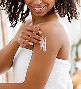 Woman rubbing lotion on her shoulder