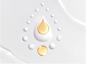 Golden and white droplets arranged on a smooth, white surface in a teardrop pattern. 