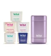 Collection of skincare products including purple bottle and white containers arranged together.