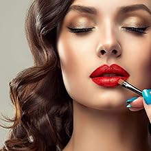Close-up of red lipstick being applied with a makeup brush.