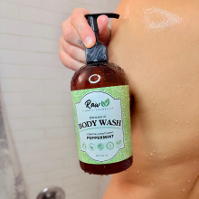 Woman in shower holding organic peppermint body wash – refreshing, natural, and sulfate-free.