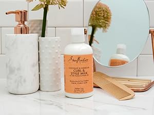 SheaMoisture Style Milk bottle on white marble bathroom counter with white tiles and accessories.