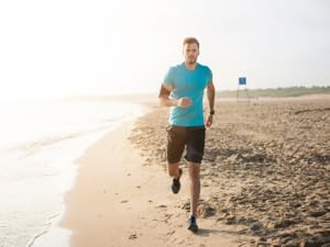 man running on beach in blue shirt