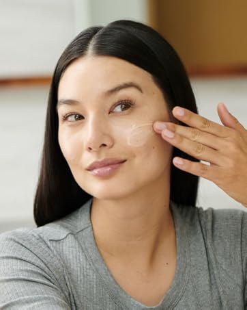 Model putting vitamin c concentrate on skin