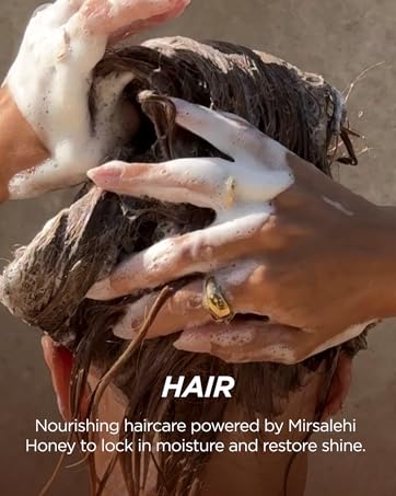 Hands massaging foamy hair during wash, showing Gisou’s nourishing honey haircare ritual