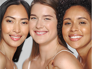 Three smiling women with smooth, rejuvinated skin