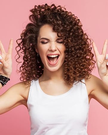 girl with beautiful curly hair posing with a v-symbol using both hands