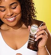 Woman holding a bottle of Jergens Instant Sun Moisturizer