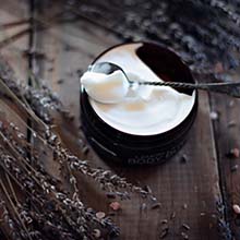 Freshly-made moisturizer on table with lavender