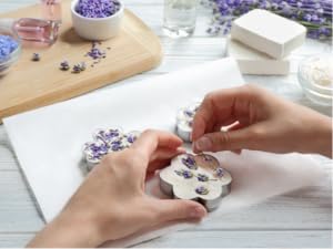 Woman finalizing soap making with fragrance oils for soap making and lavender plants.