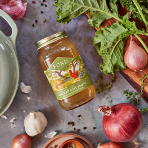 Chicken bone broth surrounded by veggies