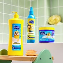 Three Suave Kids Minions products on a counter: 3-in-1 shampoo, detangler, & slime. Green tiles.