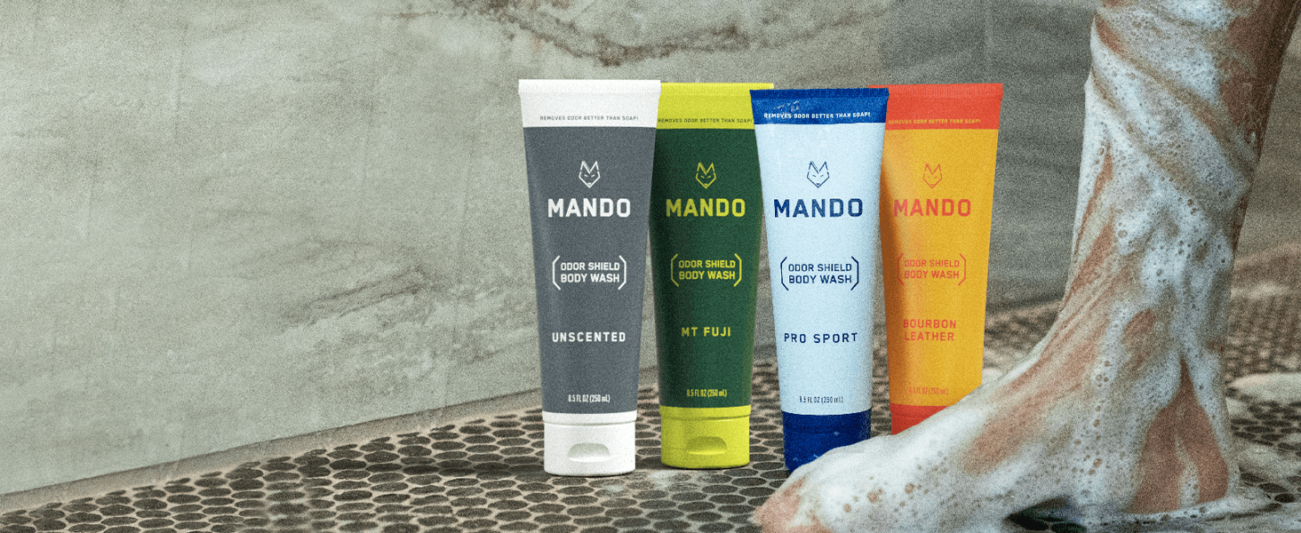Mando Body Wash tubes on the shower floor in Unscented, Mt Fuji, Pro Sport, and Bourbon Leather