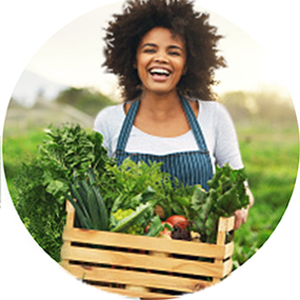 Woman holding farm fresh veggies & fruits.
