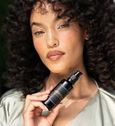 beautiful model holding gold serum anti aging skincare alitura pure ingredients 95% organic