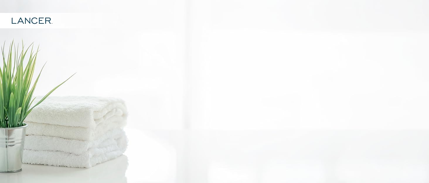 Folded white towels and a green plant on a white background. Text reads: 
