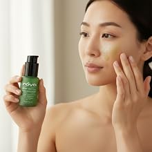 an asian women holding a green serum applies it to her face